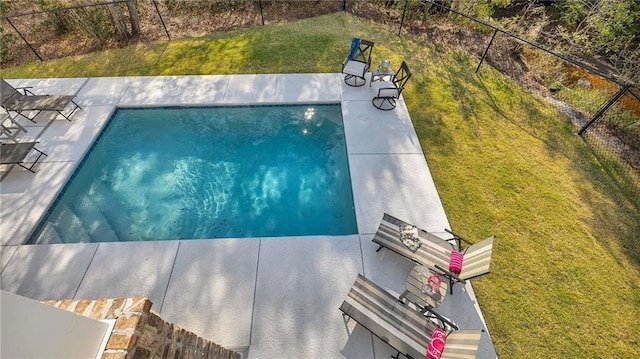 view of pool featuring a lawn