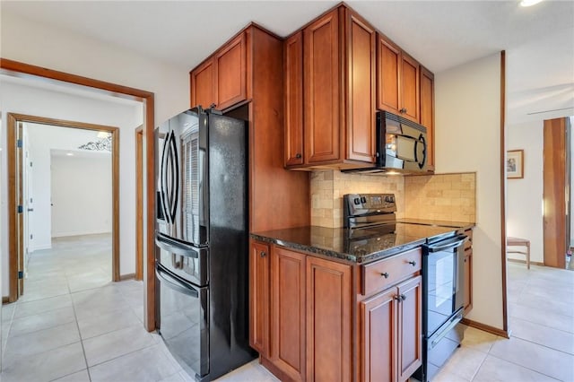 kitchen featuring dark stone countertops, decorative backsplash, light tile patterned floors, and black appliances