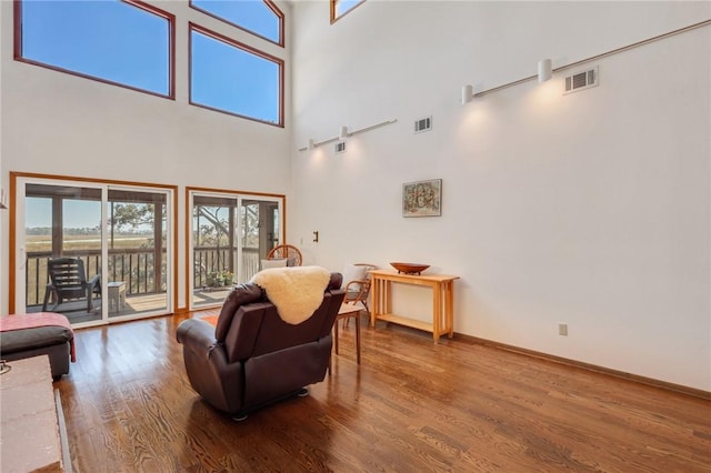 living room with wood-type flooring and a high ceiling