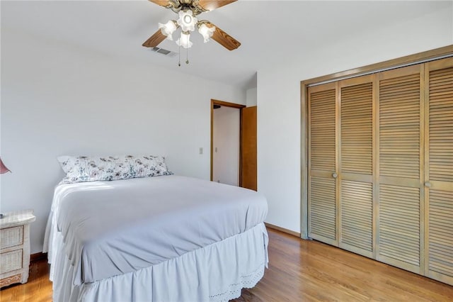 bedroom featuring ceiling fan, light hardwood / wood-style floors, and a closet