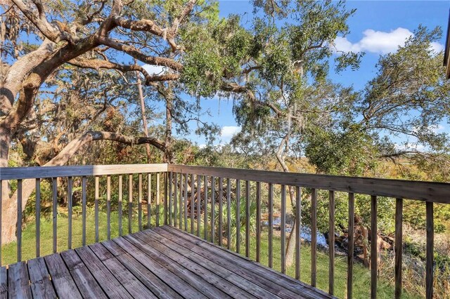 wooden deck featuring a lawn