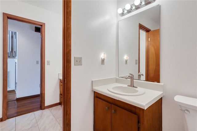 bathroom with hardwood / wood-style floors, vanity, and toilet