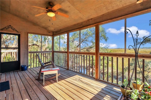 unfurnished sunroom featuring ceiling fan, a wealth of natural light, and vaulted ceiling