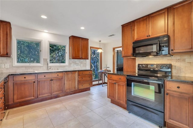 kitchen featuring tasteful backsplash, pendant lighting, sink, and black appliances