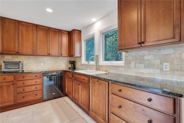 kitchen with sink, decorative backsplash, dark stone countertops, light tile patterned floors, and black dishwasher