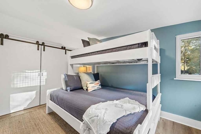 bedroom featuring a barn door and wood-type flooring