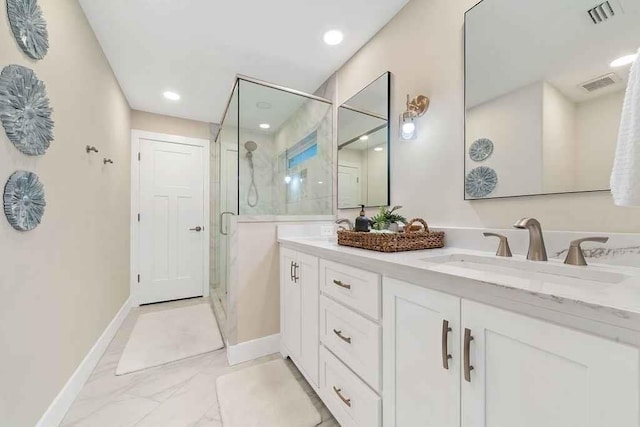 bathroom featuring a shower with door and vanity