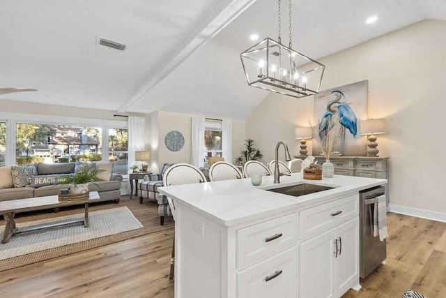 kitchen featuring sink, a center island with sink, light hardwood / wood-style flooring, dishwasher, and white cabinetry