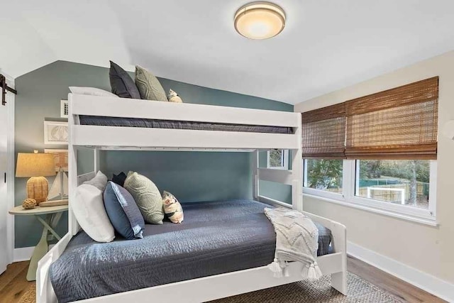 bedroom featuring hardwood / wood-style floors and vaulted ceiling