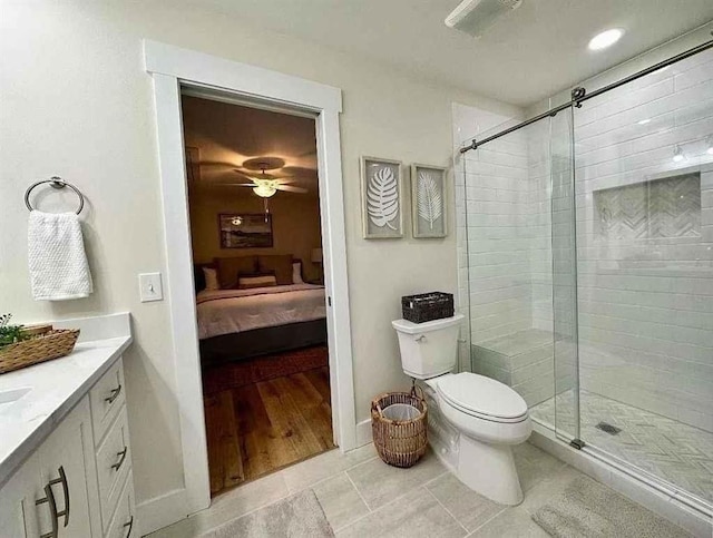 bathroom featuring walk in shower, vanity, ceiling fan, tile patterned flooring, and toilet