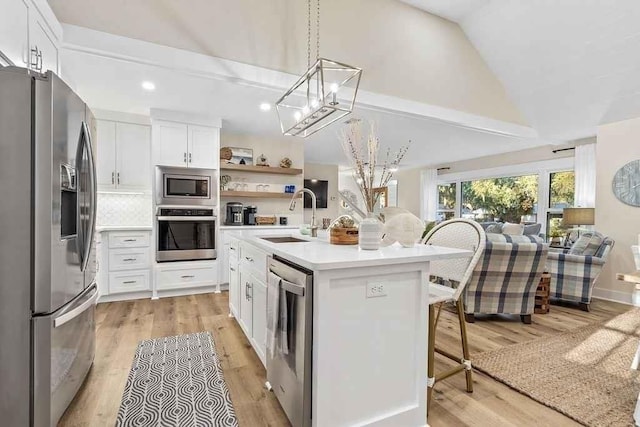 kitchen featuring appliances with stainless steel finishes, a center island with sink, white cabinetry, and sink