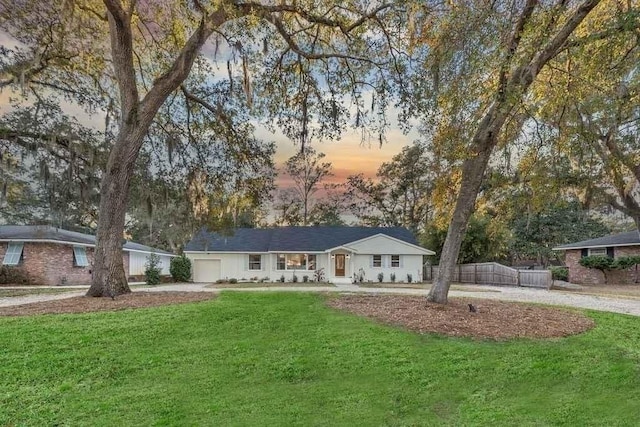 ranch-style home with a garage and a yard