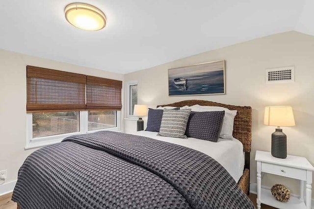 bedroom featuring wood-type flooring and vaulted ceiling