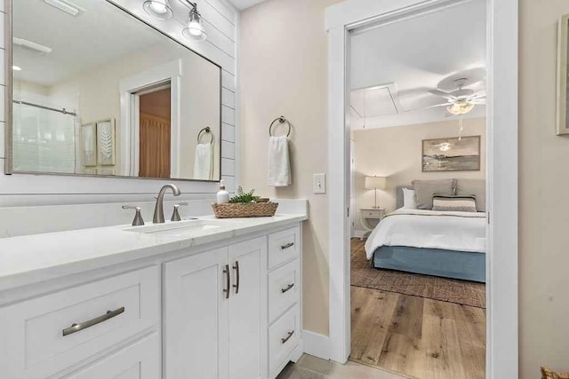 bathroom with vanity, ceiling fan, a shower with shower door, and wood-type flooring