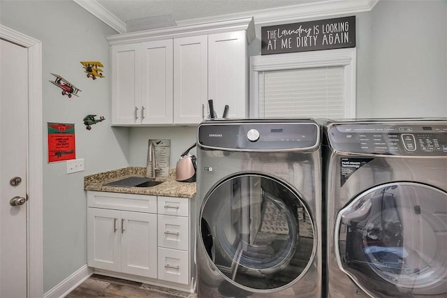 washroom with cabinets, sink, separate washer and dryer, and crown molding