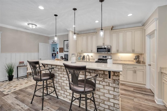 kitchen featuring cream cabinets, stainless steel appliances, and light hardwood / wood-style flooring