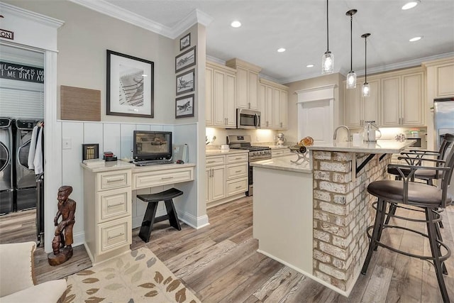 kitchen featuring washer and clothes dryer, stainless steel appliances, and cream cabinetry