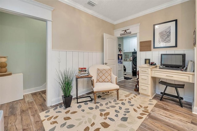 home office with crown molding and light hardwood / wood-style flooring