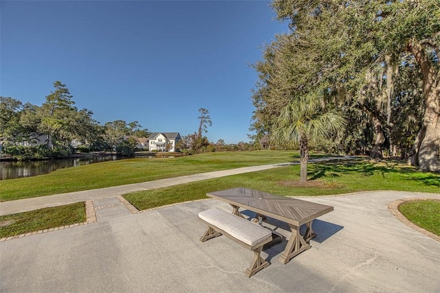 view of home's community featuring a yard, a water view, and a patio