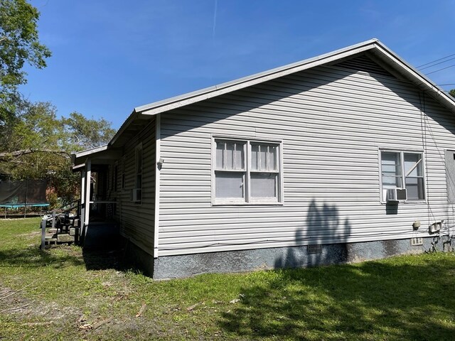 view of property exterior featuring a yard and a trampoline