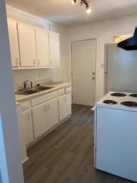 kitchen with a textured ceiling, white appliances, and white cabinetry