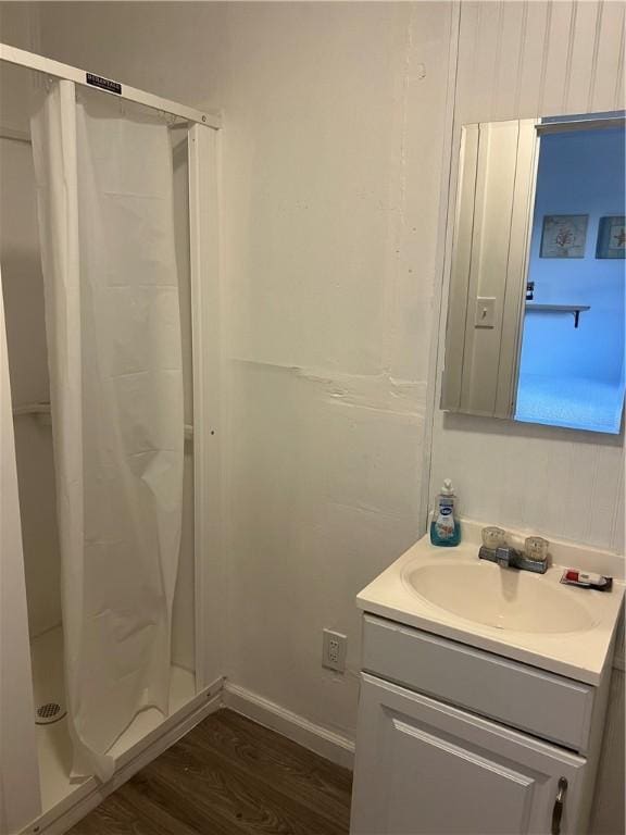 bathroom featuring walk in shower, vanity, and hardwood / wood-style flooring