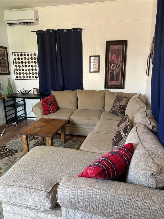 living room featuring hardwood / wood-style flooring and a wall mounted AC