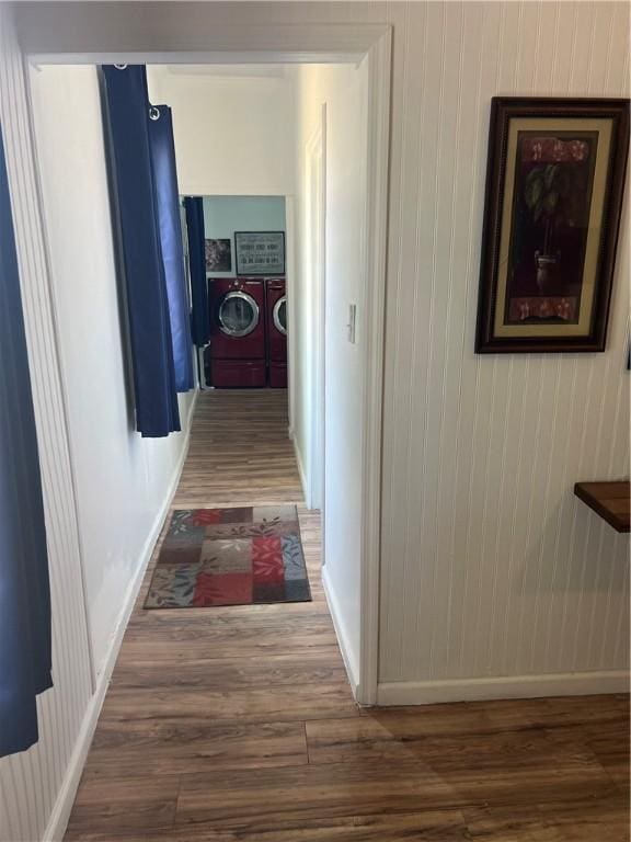 hallway with separate washer and dryer and wood-type flooring