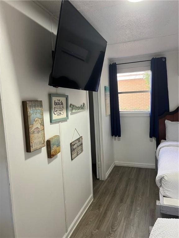 bedroom with dark hardwood / wood-style flooring and a textured ceiling