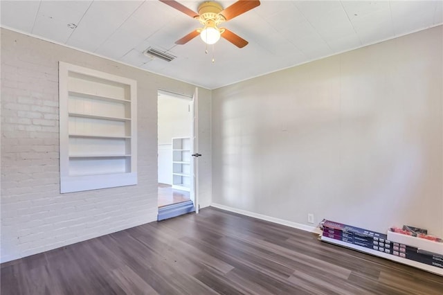 unfurnished room with ceiling fan, built in features, and dark wood-type flooring