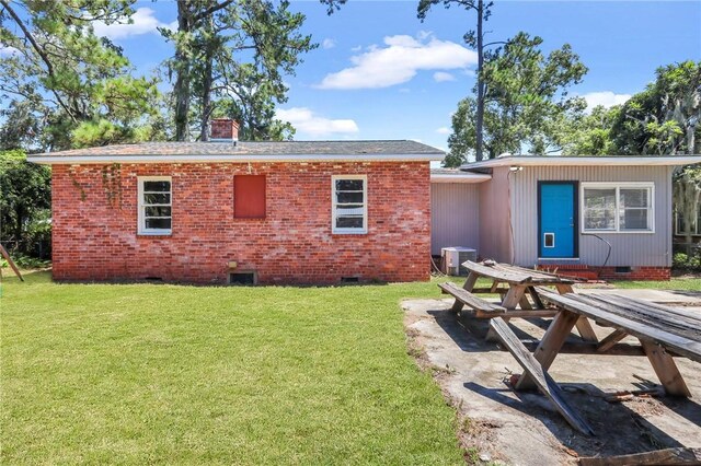 view of front of property with central air condition unit and a front lawn