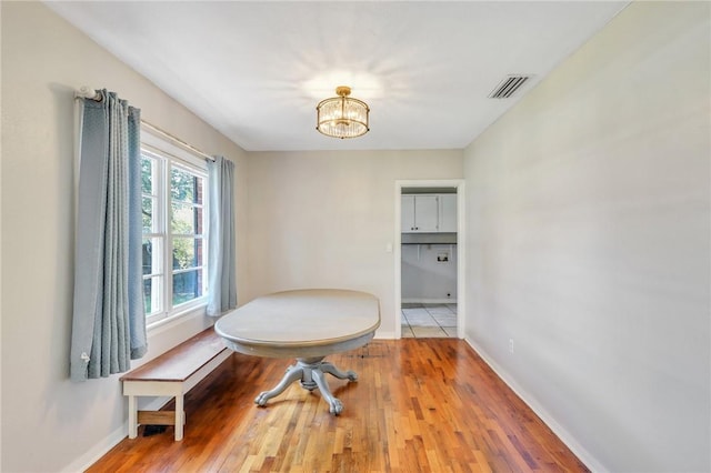 dining area featuring hardwood / wood-style floors and an inviting chandelier