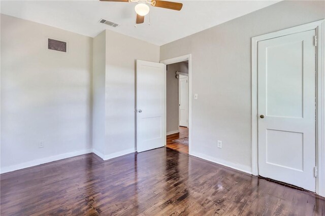 unfurnished bedroom featuring ceiling fan and dark wood-type flooring