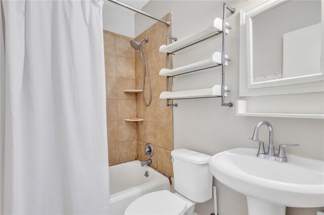 full bathroom with toilet, sink, and shower / tub combo with curtain