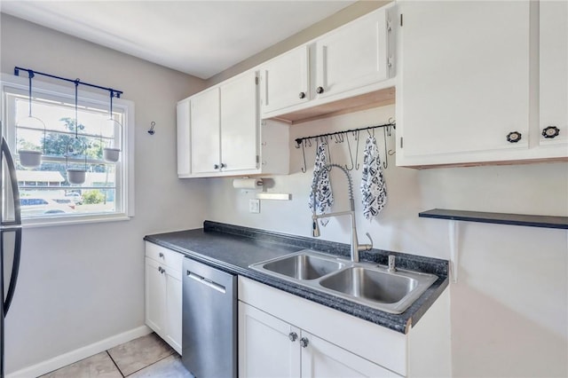 kitchen featuring sink, white cabinets, stainless steel dishwasher, and light tile patterned floors