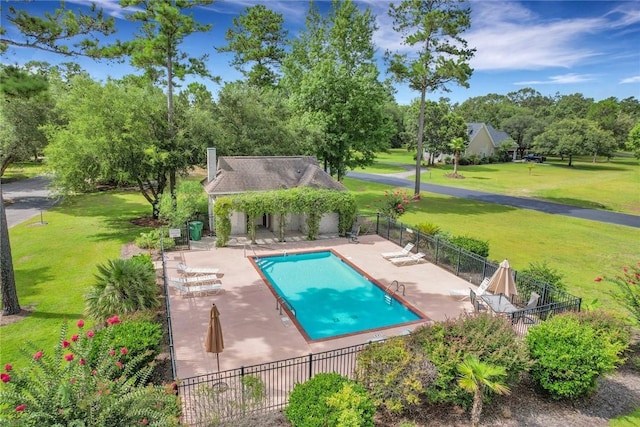 view of pool featuring a yard, an outdoor structure, and a patio area