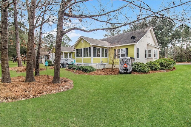 view of front facade with a sunroom and a front yard