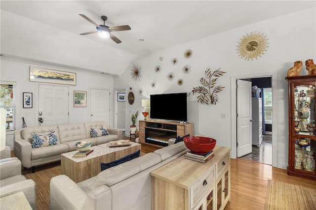 living room with vaulted ceiling, ceiling fan, and light hardwood / wood-style floors