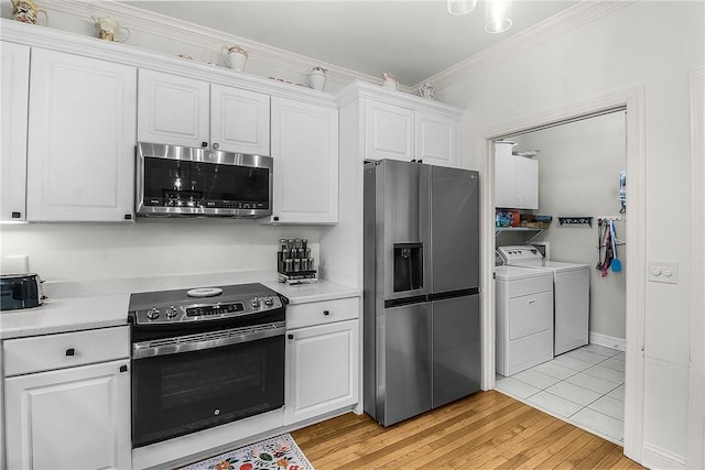 kitchen featuring light hardwood / wood-style flooring, appliances with stainless steel finishes, ornamental molding, independent washer and dryer, and white cabinets