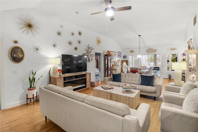 living room featuring vaulted ceiling, ceiling fan, and light hardwood / wood-style flooring