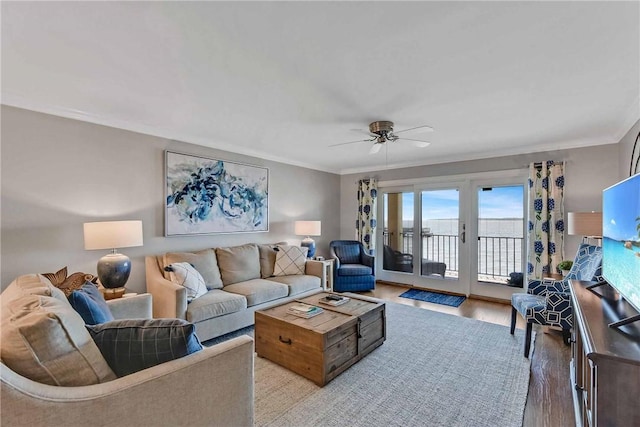 living room featuring ceiling fan, light hardwood / wood-style floors, ornamental molding, and french doors