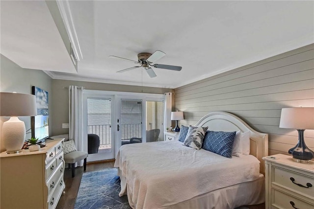 bedroom featuring access to exterior, ornamental molding, ceiling fan, dark hardwood / wood-style floors, and wood walls