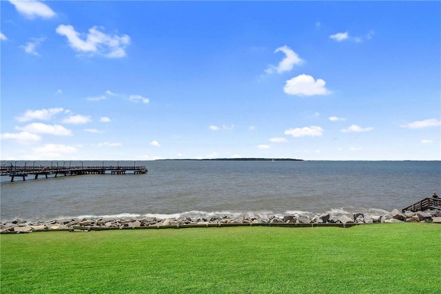 dock area with a yard and a water view