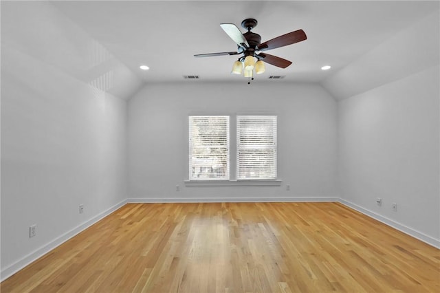 empty room featuring ceiling fan, vaulted ceiling, and light hardwood / wood-style flooring