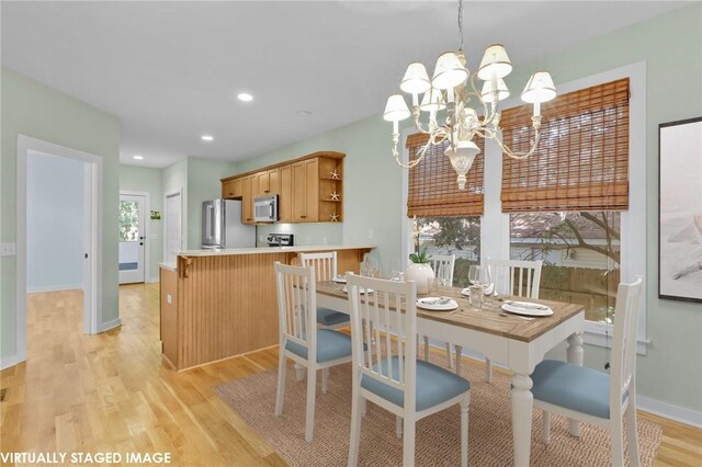 dining area with light hardwood / wood-style floors and a notable chandelier