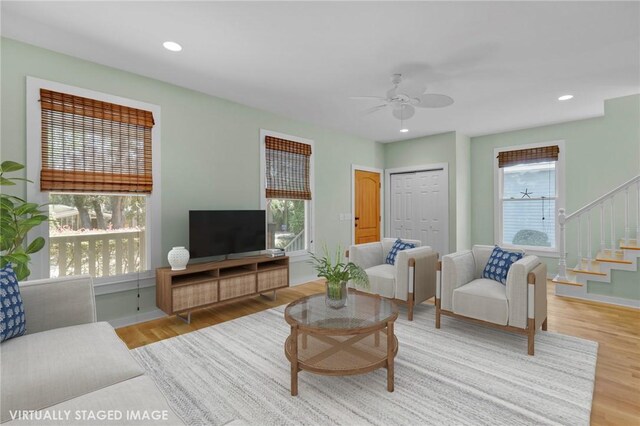 living room with a wealth of natural light, ceiling fan, and light wood-type flooring