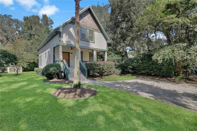 view of front of home with ceiling fan, covered porch, and a front yard