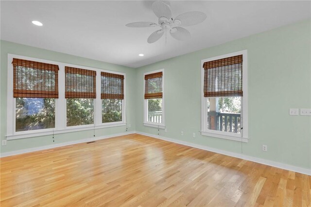 unfurnished room featuring ceiling fan, a wealth of natural light, and light hardwood / wood-style flooring