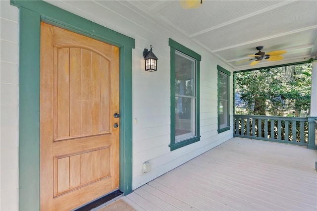 view of exterior entry with ceiling fan and a porch