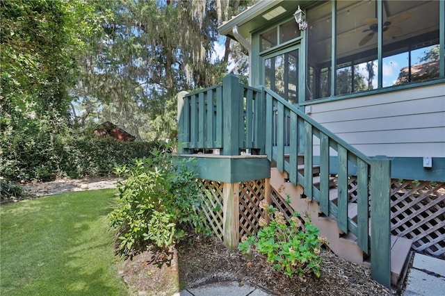 exterior space featuring a lawn, ceiling fan, and a sunroom